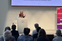 Prof. Döring spricht an einem Rednerpult vor Publikum und einer Leinwand beim Colloquium Fundamentale